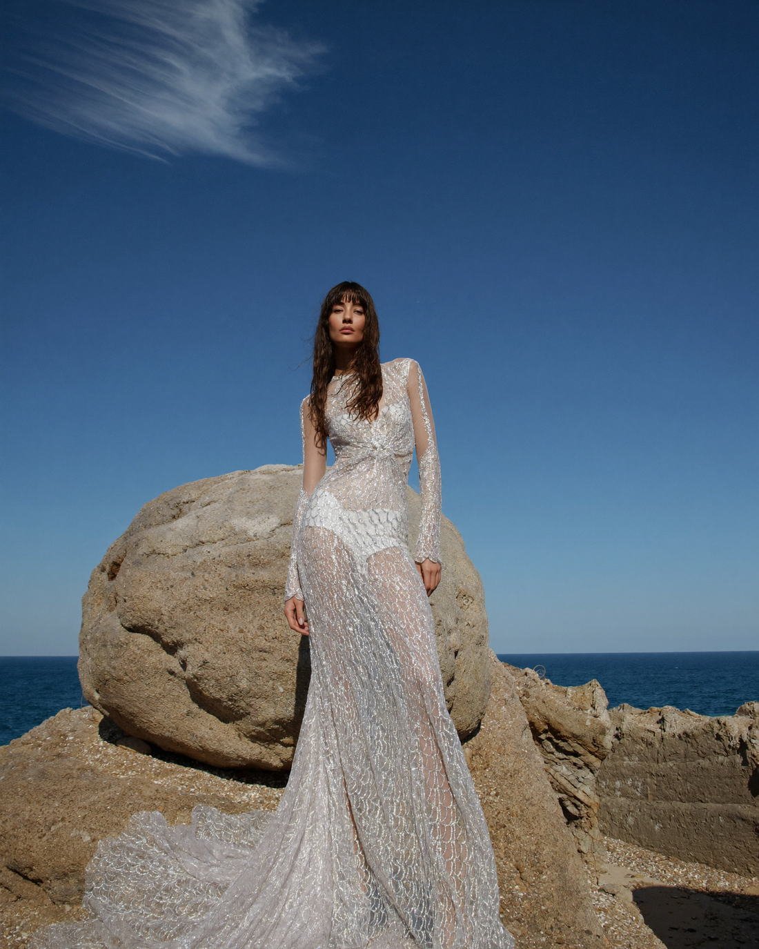 Beaded gown photographed against sea and rock, The Atelier Muse