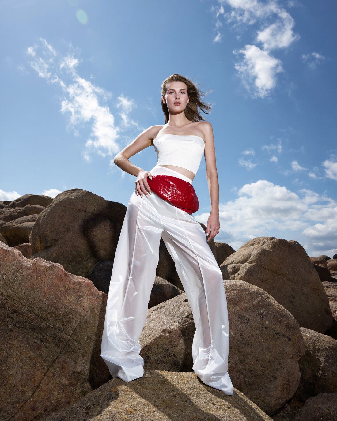 White wide-leg trousers with a red accent on desert rock, Daughter of the Wind