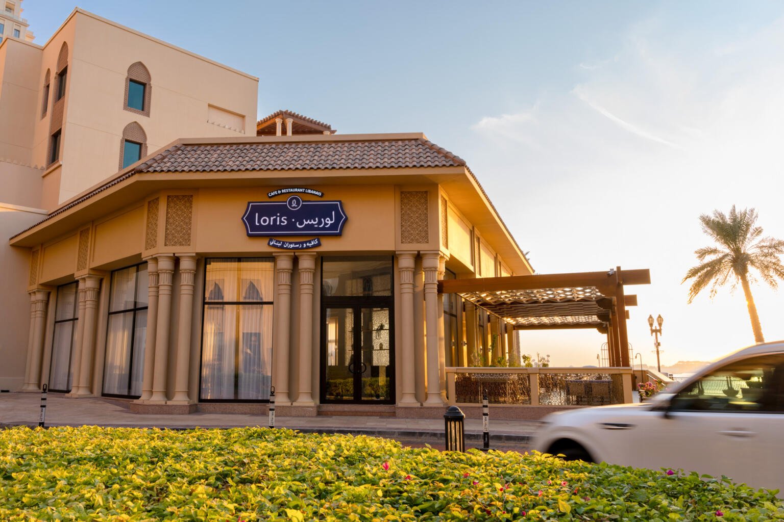 Loris restaurant building at dusk with residential towers behind it in Doha