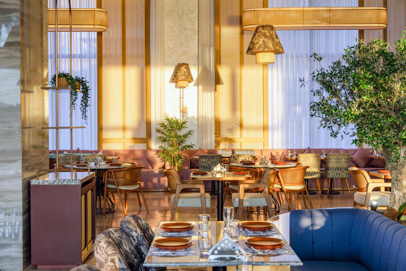 Loris dining room with blue banquettes, patterned cushions and hanging lanterns