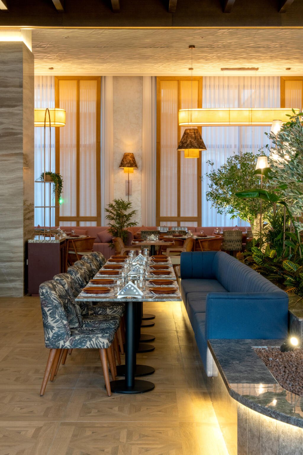 Dining room at Loris with long banquettes and a row of set tables
