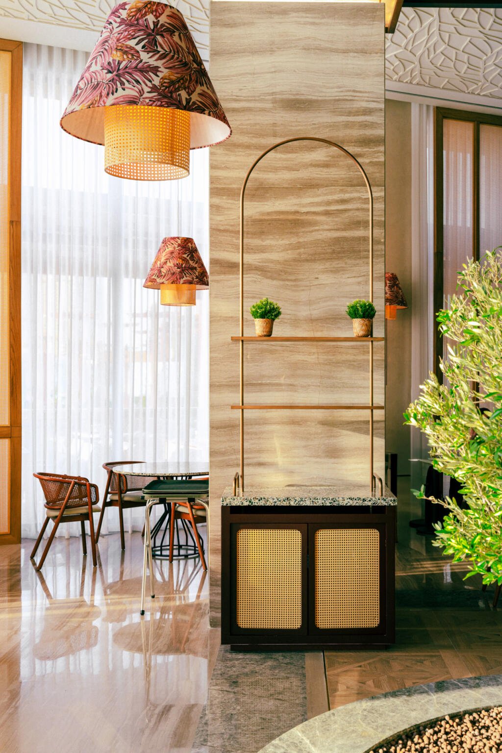 Brass shelf and planters beside a carved panel at Loris restaurant