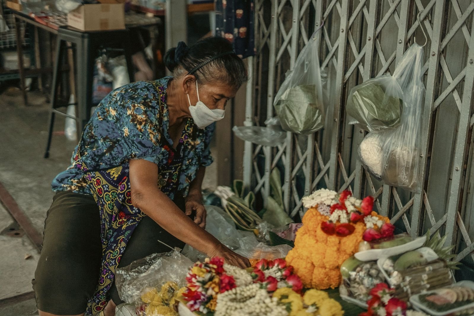 A vendor arranging marigold offerings in Bangkok, Thailand
