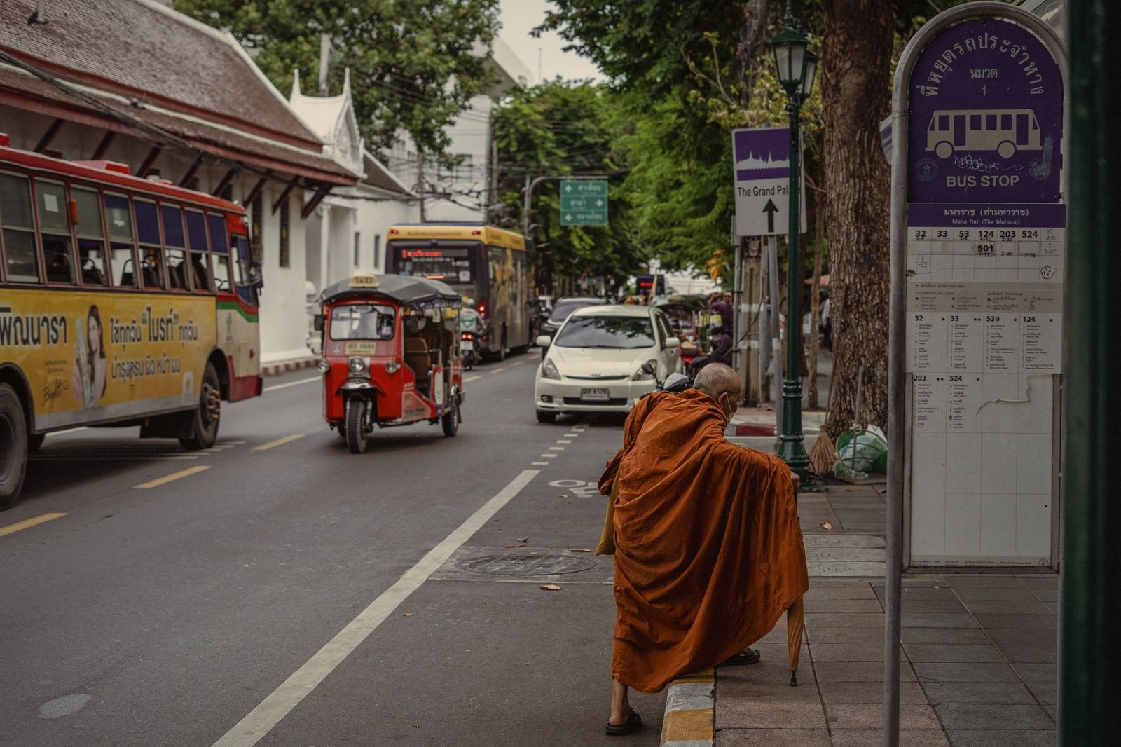 A Buddhist monk in saffron robes walking a Bangkok street, Thailand