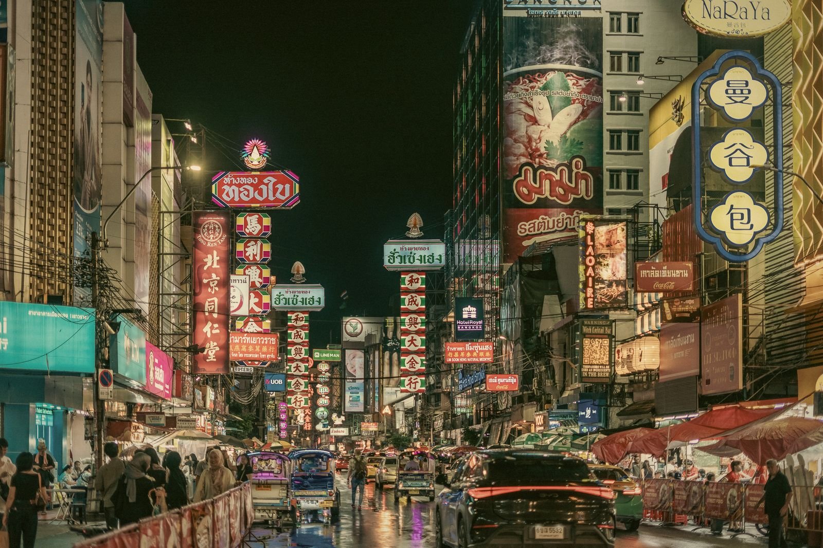 Neon signs stacked above Yaowarat Road in Bangkok