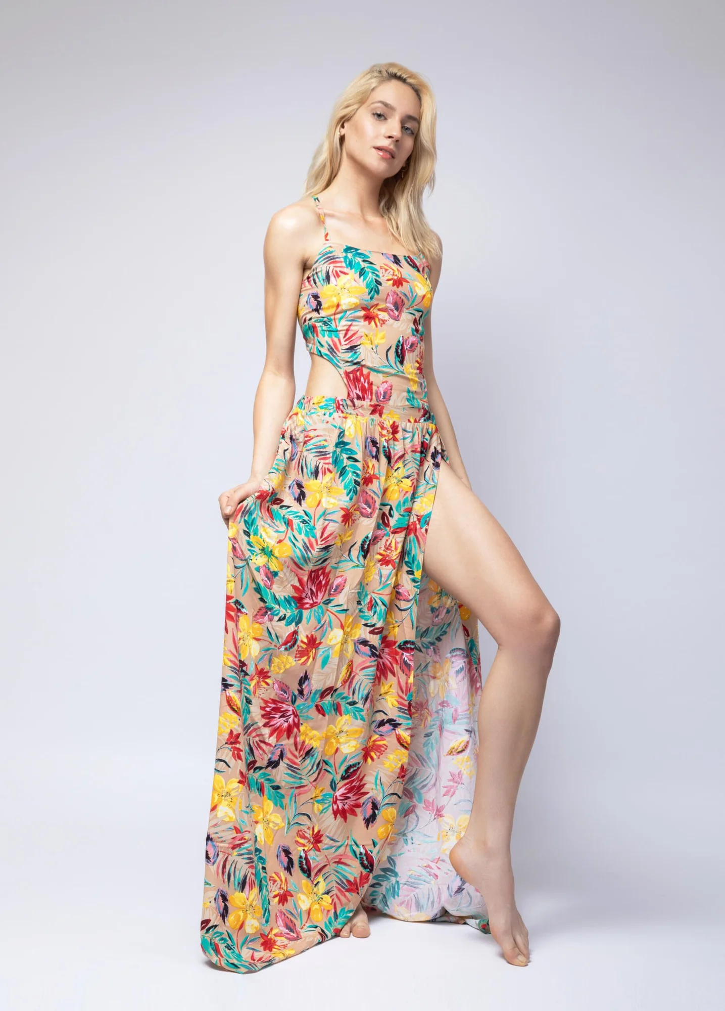 Model in a long floral dress against a plain studio background, full-length lookbook frame