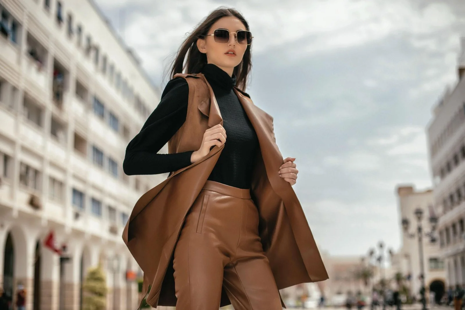 Two women in tailored autumn looks walking together on a city street, the kind of frame planned for a fashion lookbook shoot in Doha by Ghassen Oueslati