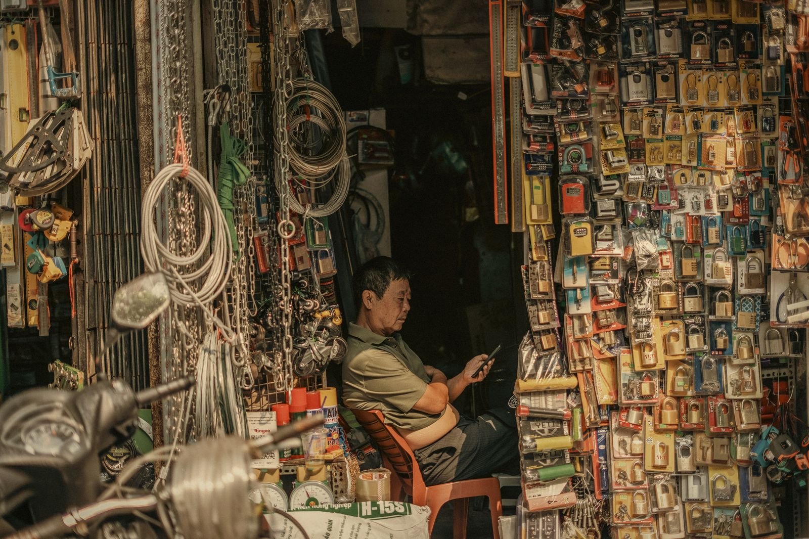 A shopkeeper among hardware and keys in an Old Quarter shop