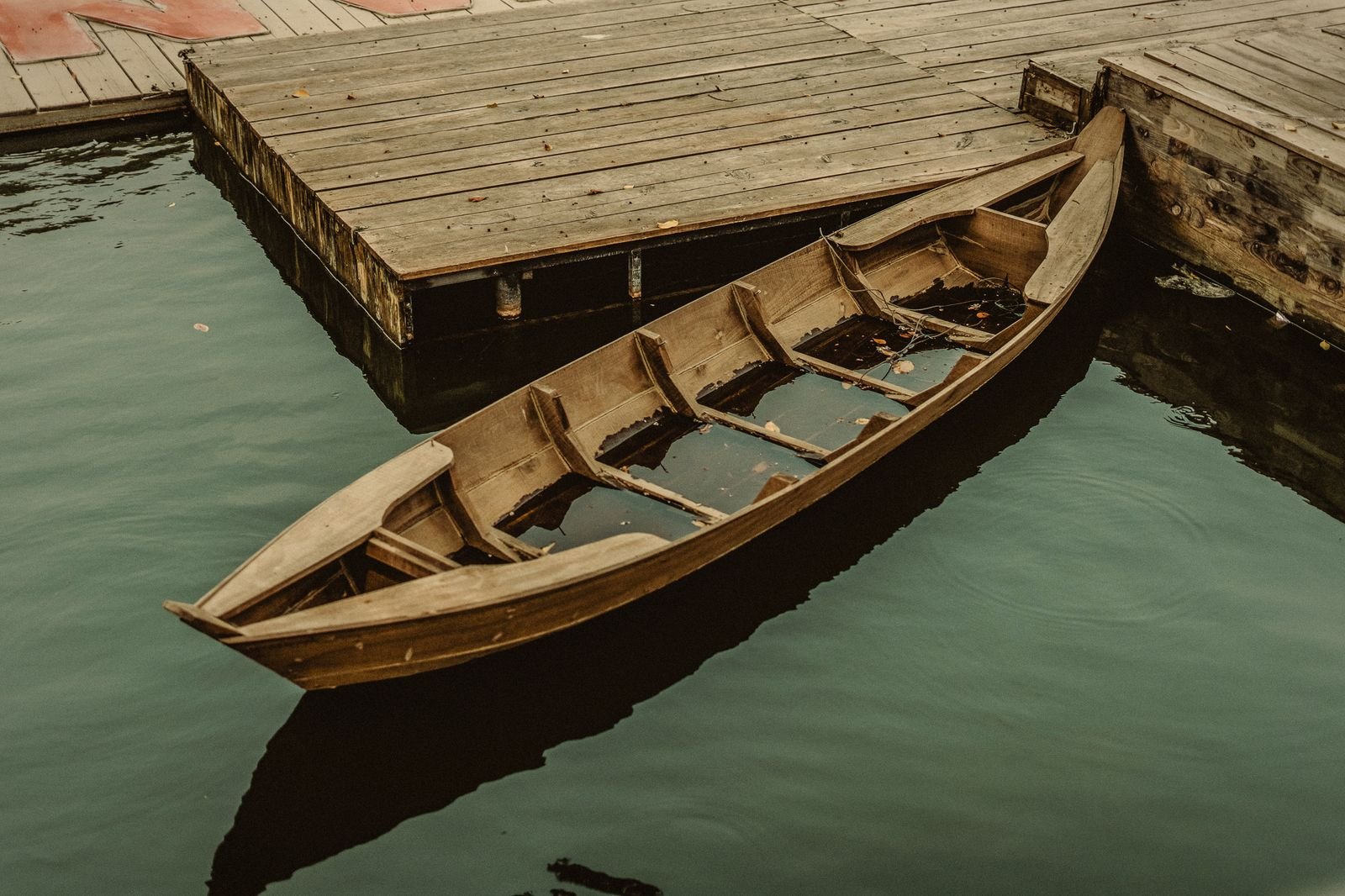 A wooden boat moored on a still lake in Hanoi
