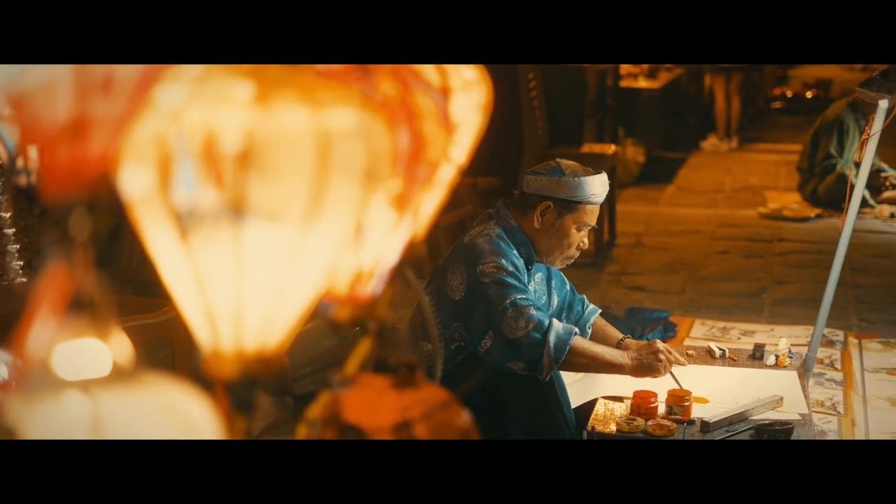Lantern maker at work under warm lantern light, poster frame from the Hoi An travel film