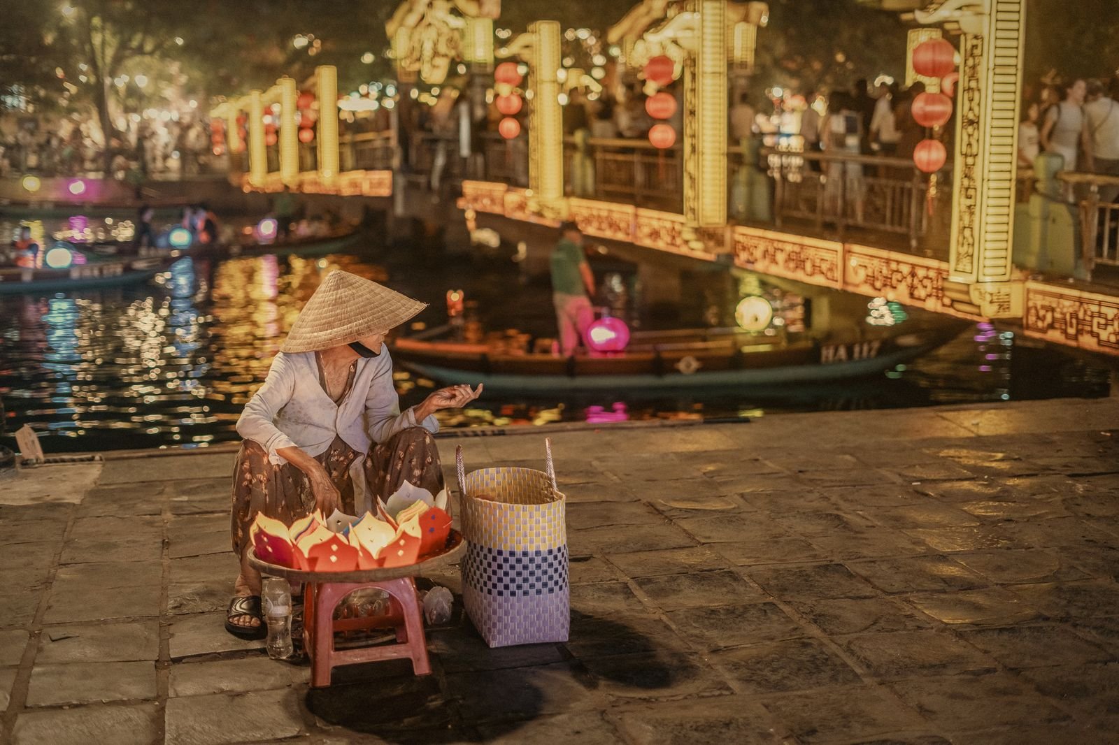 Lantern seller on the Thu Bồn riverbank in Hội An at blue hour, a highlight of this Thailand Vietnam itinerary