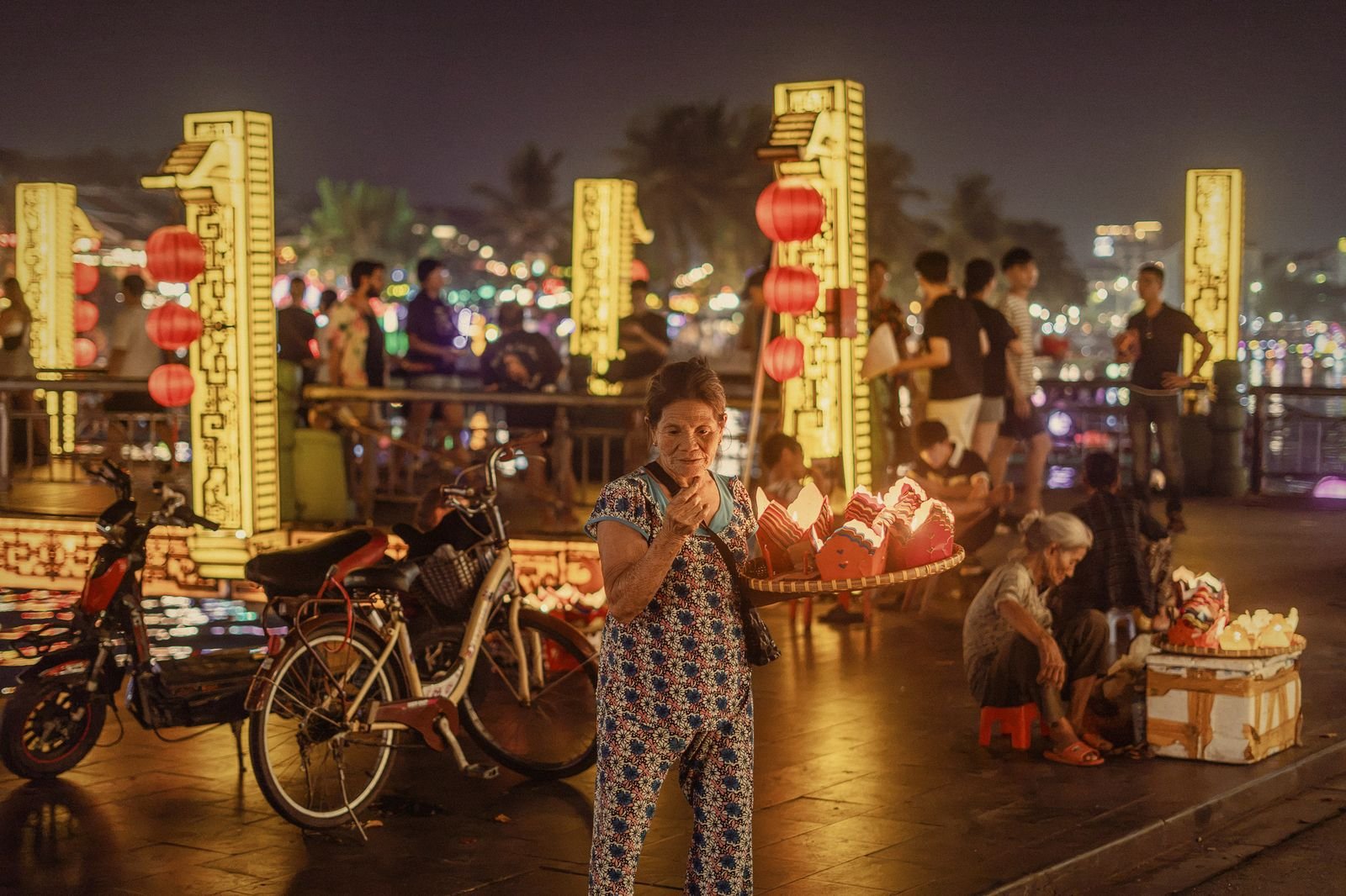 Evening vendors and scooters on a lantern-lit street in Hoi An Ancient Town