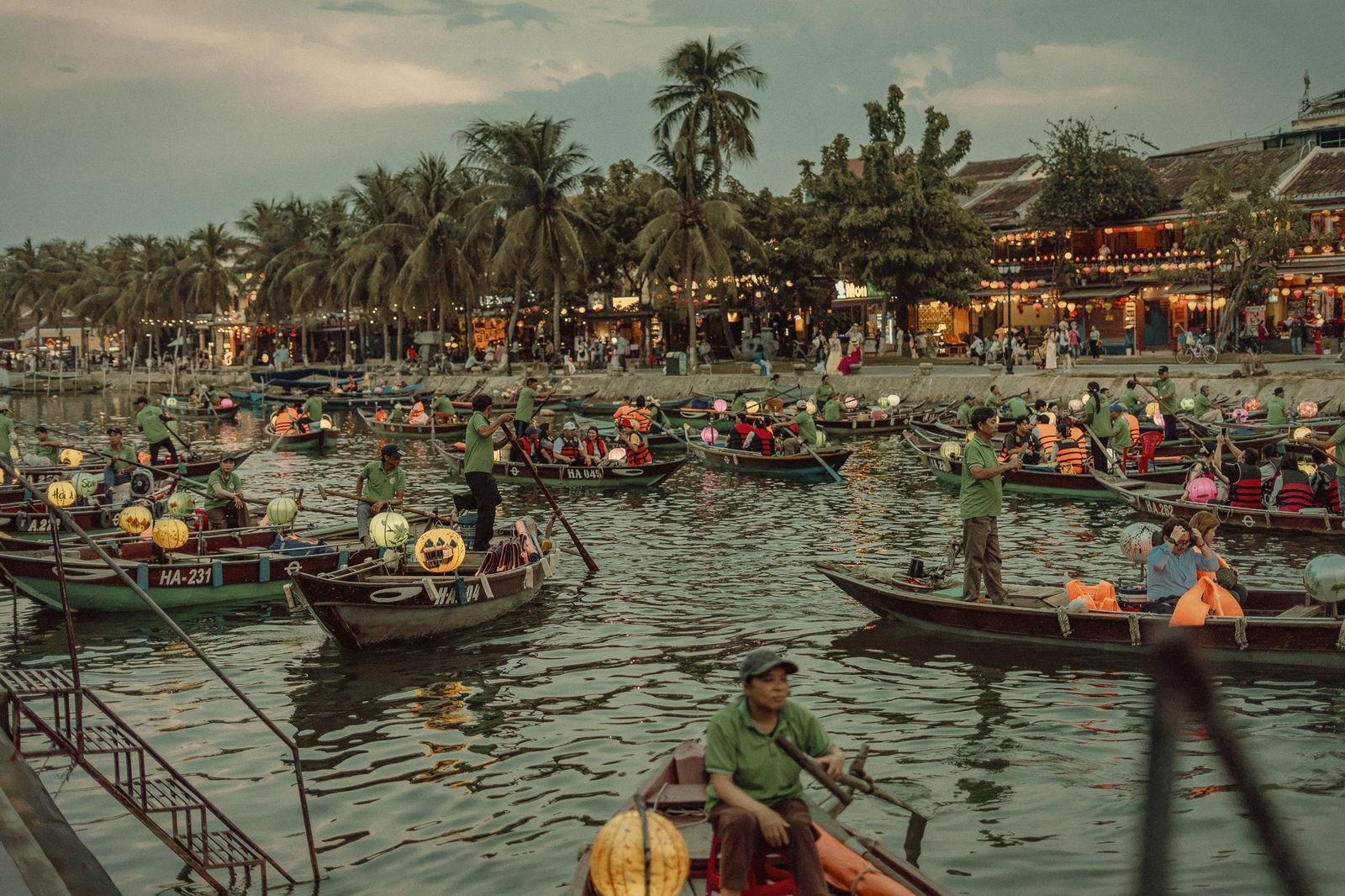 Wooden boats and conical hats on the Hoi An river in daylight