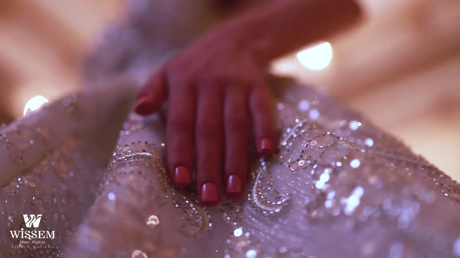 Hand resting on a beaded bridal gown, frame from In a Dream, the Wissem Ben Agha couture film