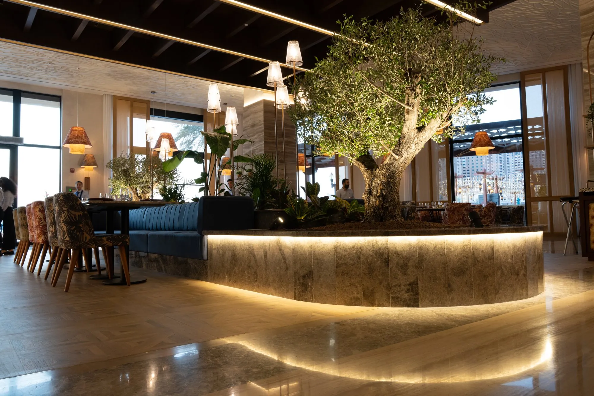 Olive tree and glowing bar counter at Loris, commercial interior photography The Pearl