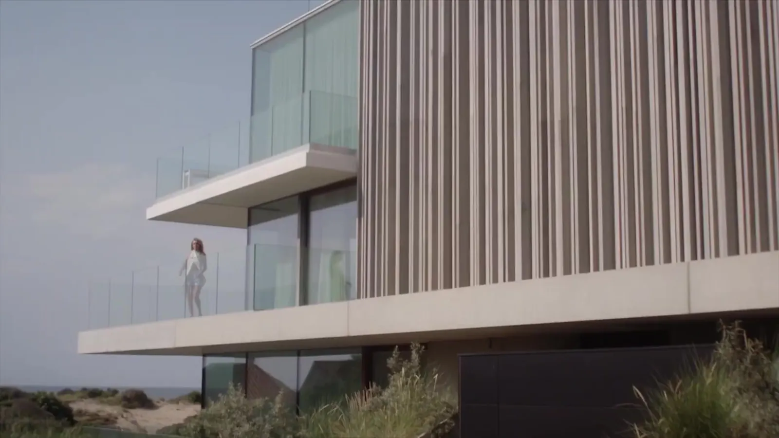 Modern house with glass balconies above the dunes, still from the Maya Paris campaign film