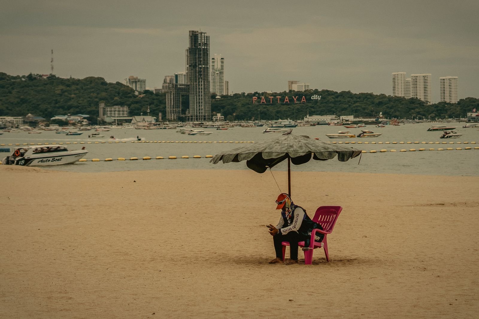 A lone pink chair and umbrella on Pattaya Beach