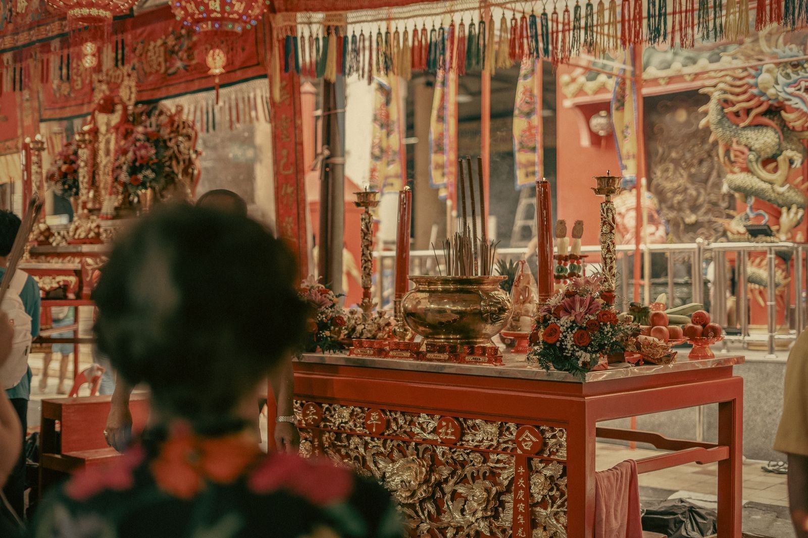 Worshippers lighting incense before a festival altar in Phuket Old Town, Thailand