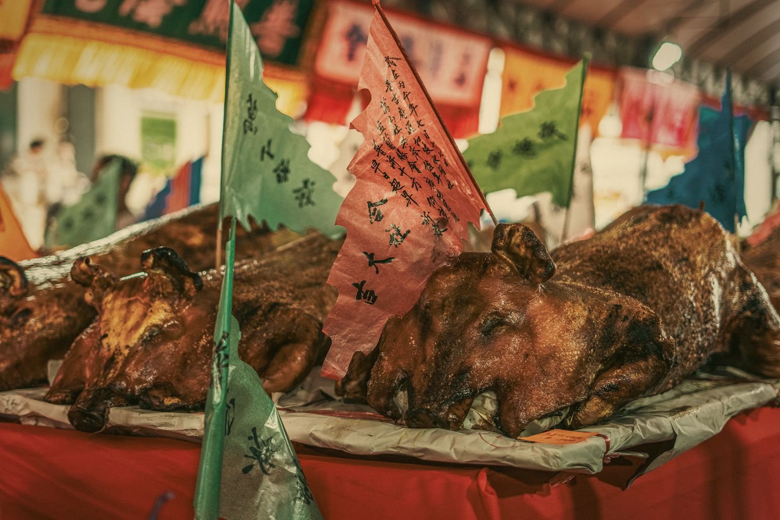 Roast pig offerings and paper flags laid out for the Por Tor festival in Phuket