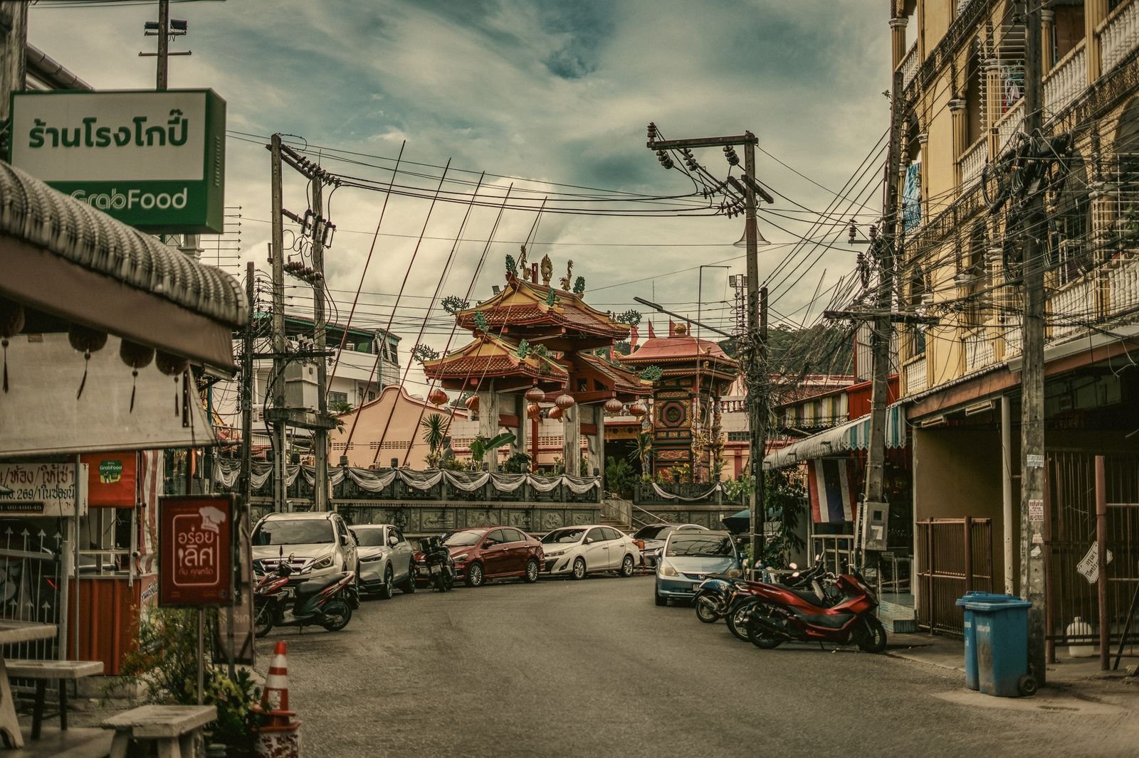 Shophouses and tangled power lines leading to a Chinese temple roof in Phuket