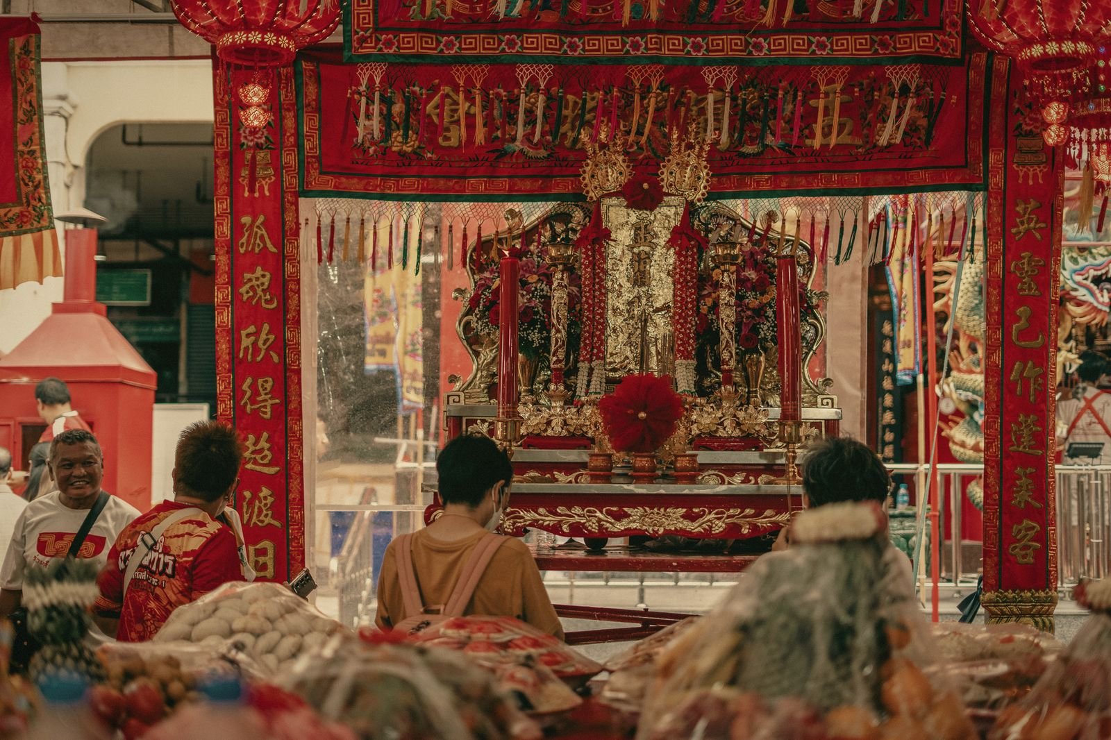 Families gathered under red lanterns at a Phuket shrine during the Por Tor festival, Thailand