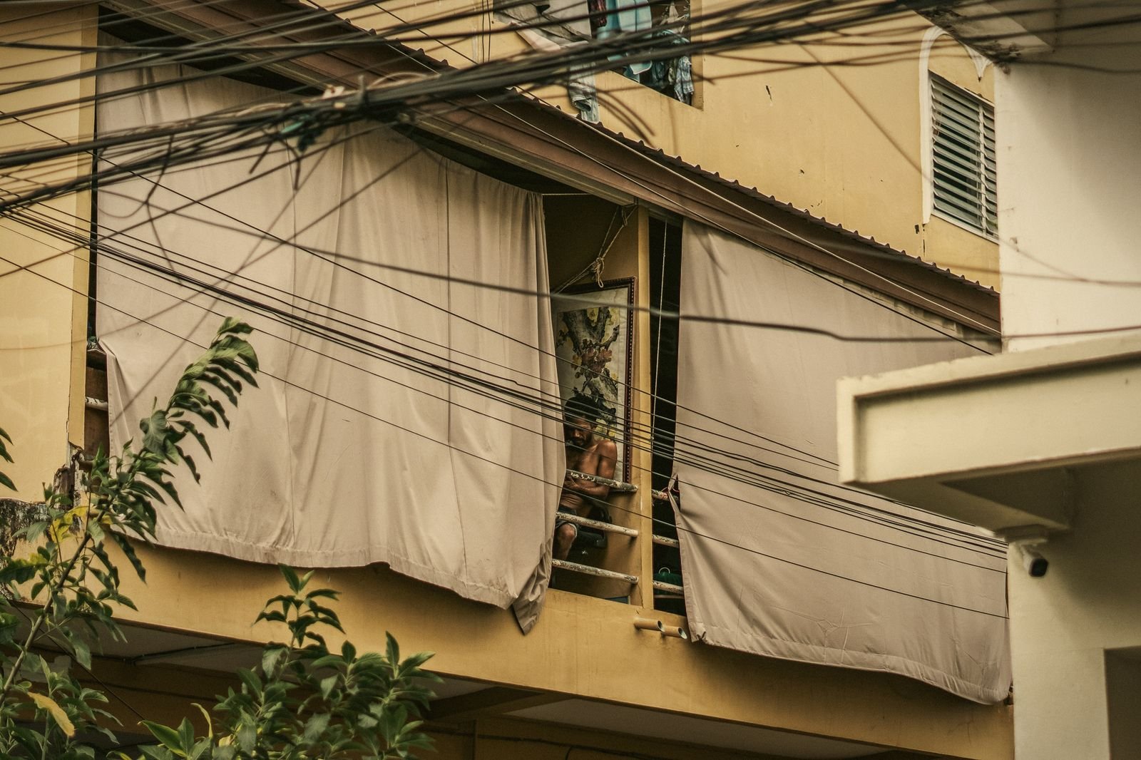 Weathered Sino-Portuguese shophouse windows with drawn blinds in Phuket Old Town