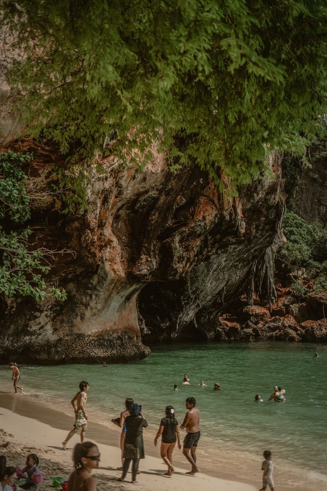 Swimmers below the cave cliffs at Phra Nang beach on the Railay peninsula