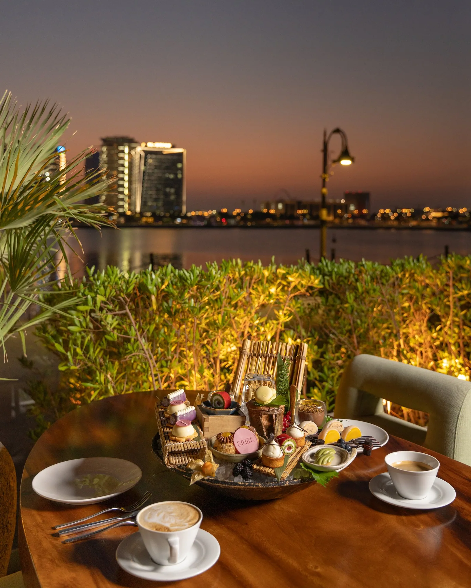 Zuma Doha new dessert tray on the terrace at sunset with the Doha skyline behind